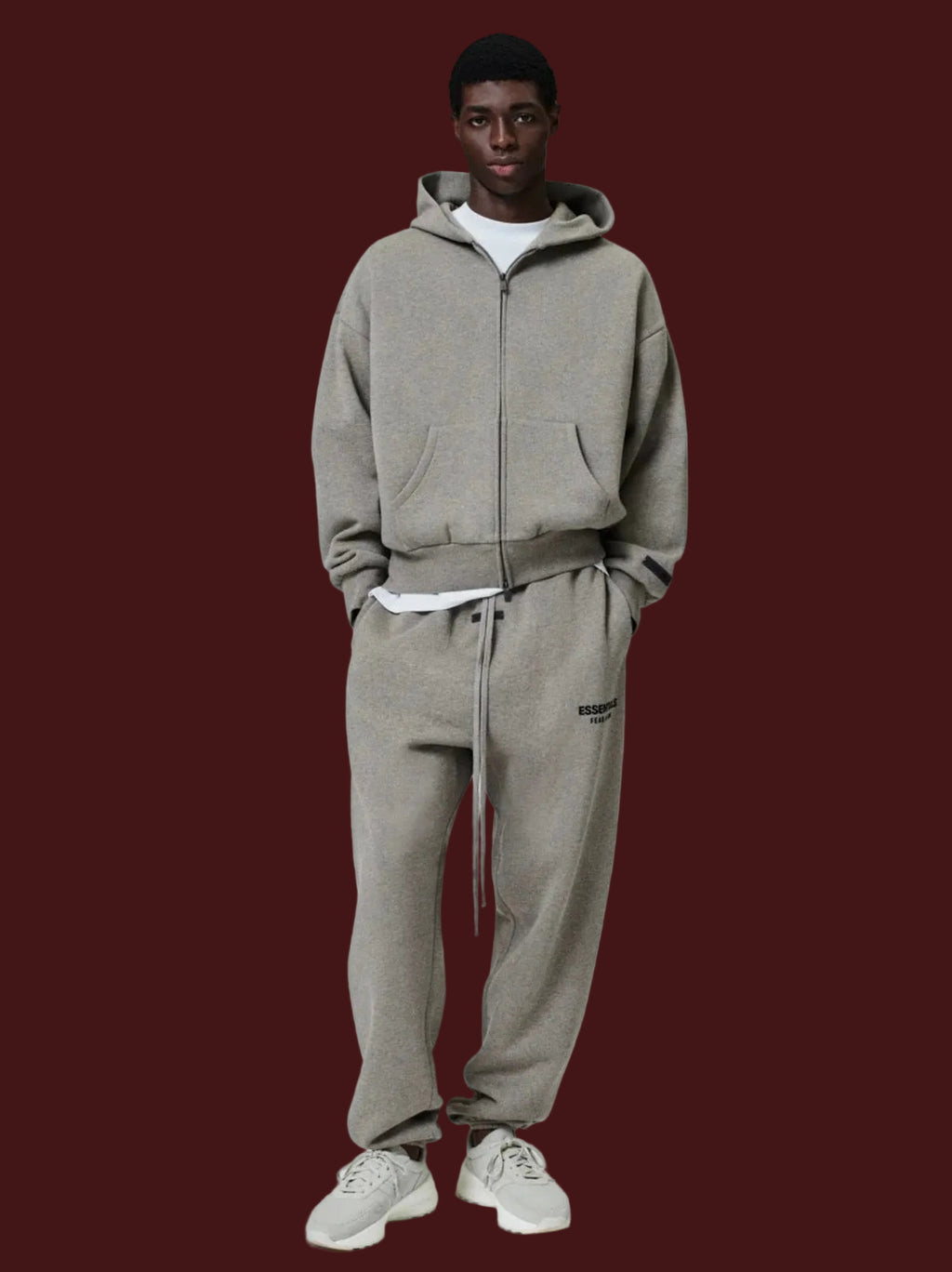 Person wearing a gray tracksuit on a white background