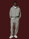 Person wearing a gray tracksuit on a white background